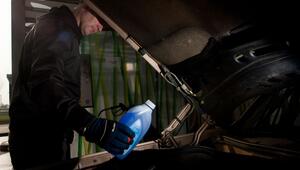 Mann füllt Frostschutzkonzentrat in die Scheibenwaschanlage