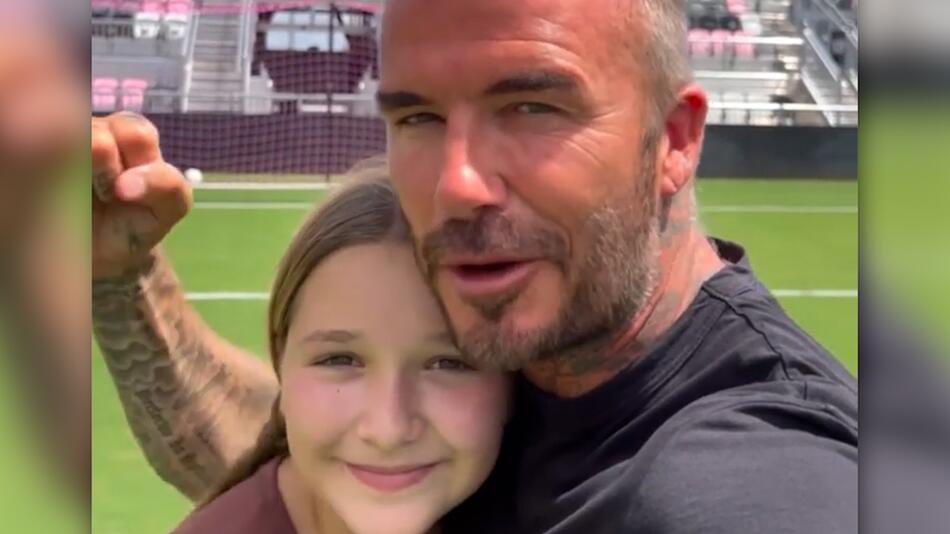 Proud dad: David Beckham shows his daughter Harper playing soccer
