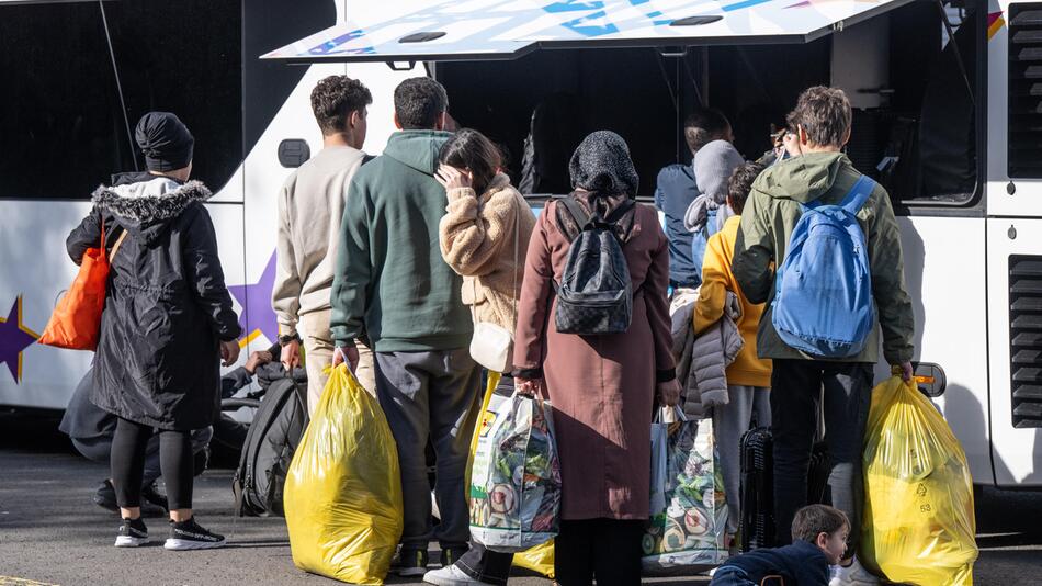 Geflüchtete vor einem Bus