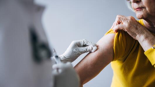 Ärztin impft eine Seniorin