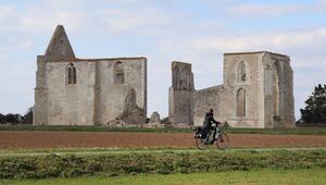 Radfahrerin vor der Ruine der Zisterzienserabtei