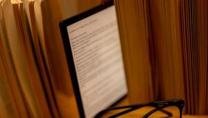 E-Book-Reader steht zwischen Büchern auf einem Tisch