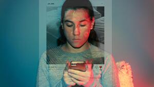 Ein 13-jähriges Mädchen benutzt ihr Handy in einem dunklen Zimmer.