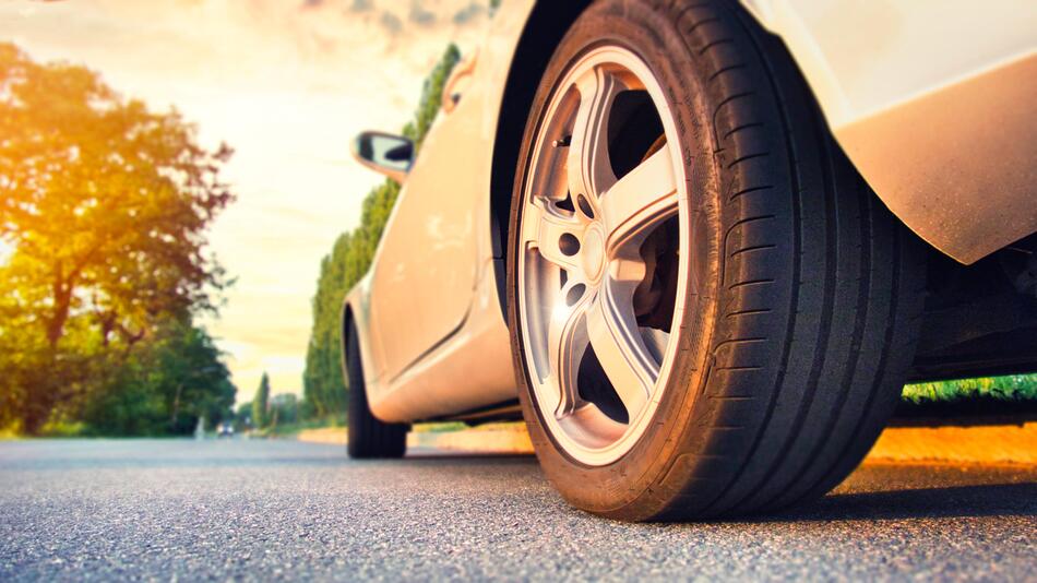 Nahaufnahme: Autoreifen im Sommerlicht auf einer Landstraße