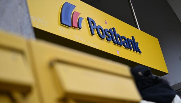 Der Schriftzug der Postbank am Eingang einer Filiale