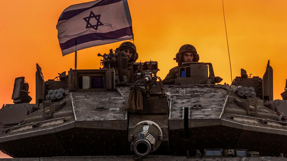 Israelische Soldaten blicken an der Grenze von Israel zum Gazastreifen aus einem Panzer.