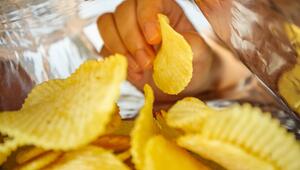 Hand greift in Chipstüte