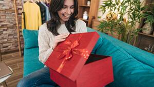 Frau freut sich beim Geschenkauspacken