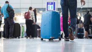 Ein Passagier geht mit einem Koffer Flughafen