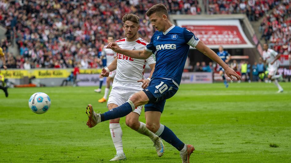 KSC-Kapitän Marvin Wanitzek flankt vor dem Kölner Jan Thielmann