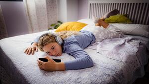 Mädchen nutzt Handy im Bett