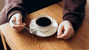 Hände und eine Tasse Kaffee auf einem Tisch