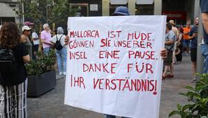 Ein Mann hält ein Schild: Mallorca ist müde