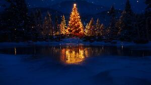 Leuchtender Weihnachtsbaum umgeben von Schnee in den Bergen