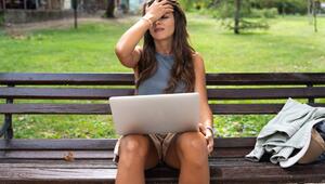 Eine Frau mit einem Laptop auf dem Schoss.