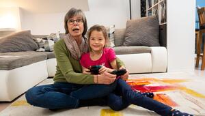 Oma spielt mit ihrer Enkelin an der Konsole