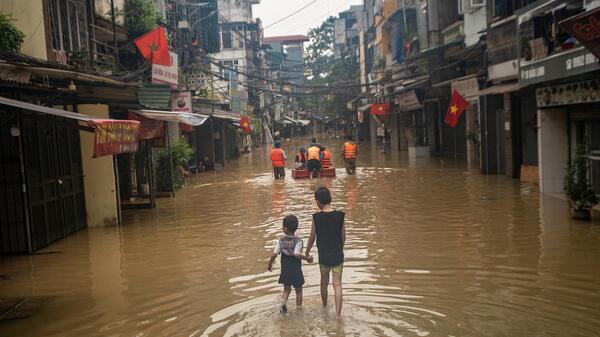 Zwei Kinder in Vietnam waten durch Wasser