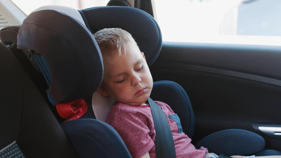 Ein Junge im Kindersitz im Auto.