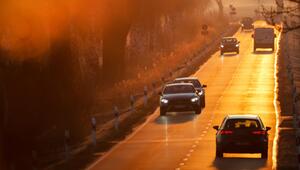 Autos fahren bei aufgehender Sonne auf einer Landstraße