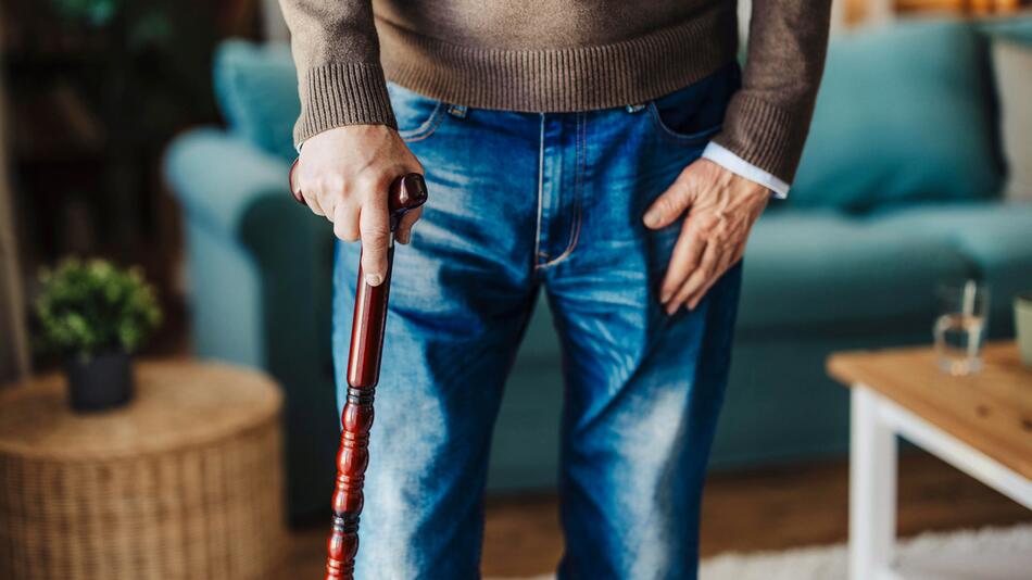 Mann geht am Stock, Parkinson