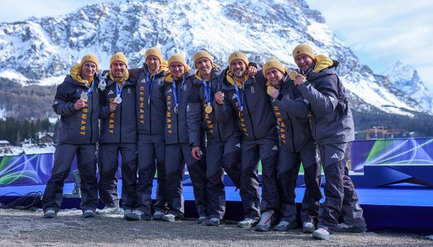 Acht deutsche Bobfahrer feiern ihren Doppelsieg im Viererbob.