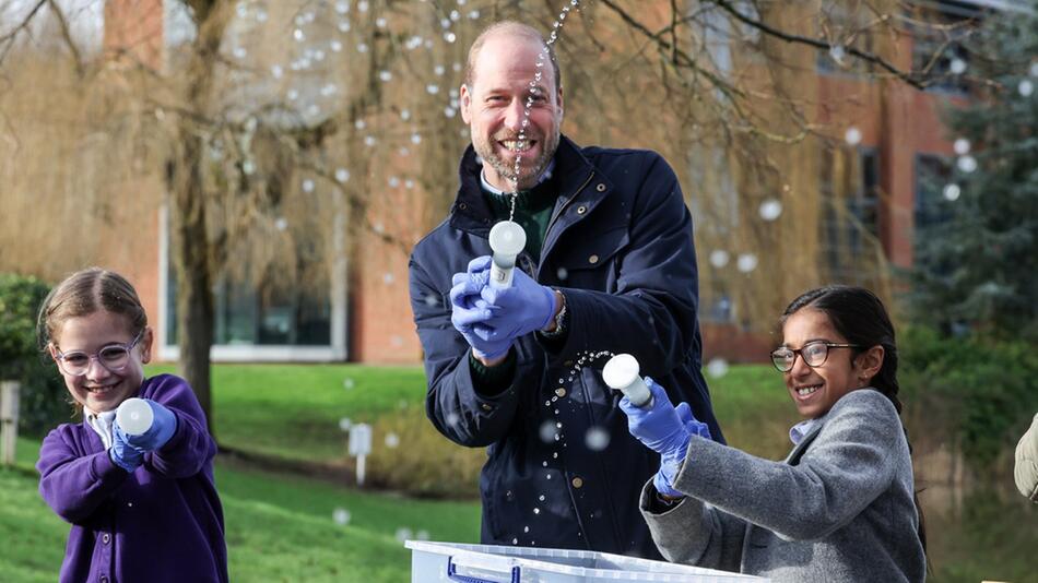 Prinz William hatte sichtlich Spaß, als er mit Schulkindern in Surrey Wasser in Richtung der ...