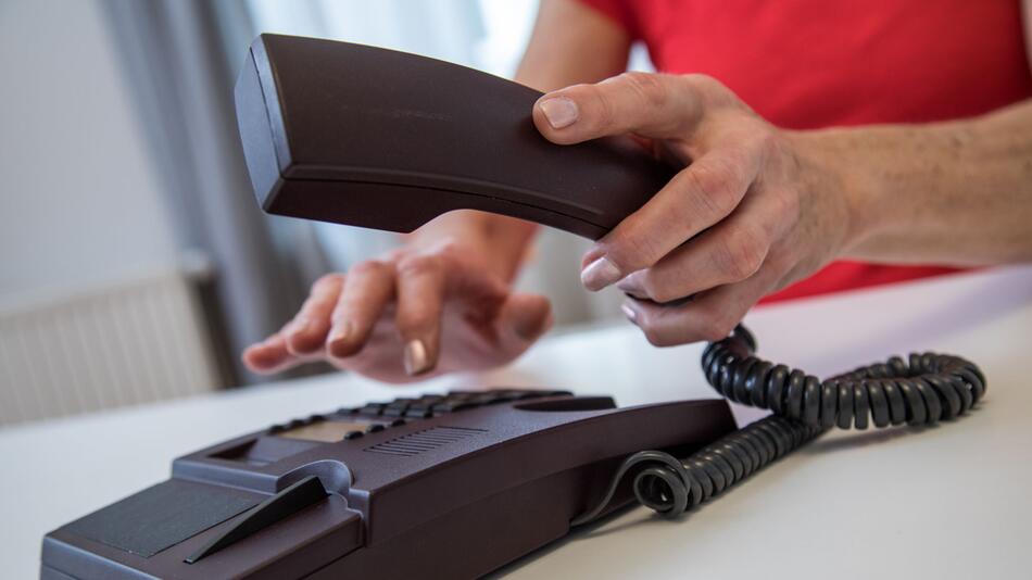 Eine Frau benutzt ein Festnetztelefon