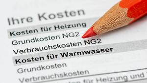 Ein roter Buntstift zeigt auf Heizungs- und Warmwasserabrechnung.