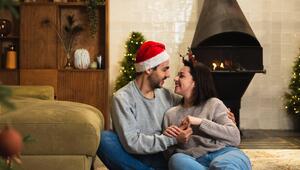 Paar sitzt gemeinsam im weihnachtlich dekorierten Wohnzimmer 