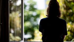 Eine Frau steht an einem offenen Fenster