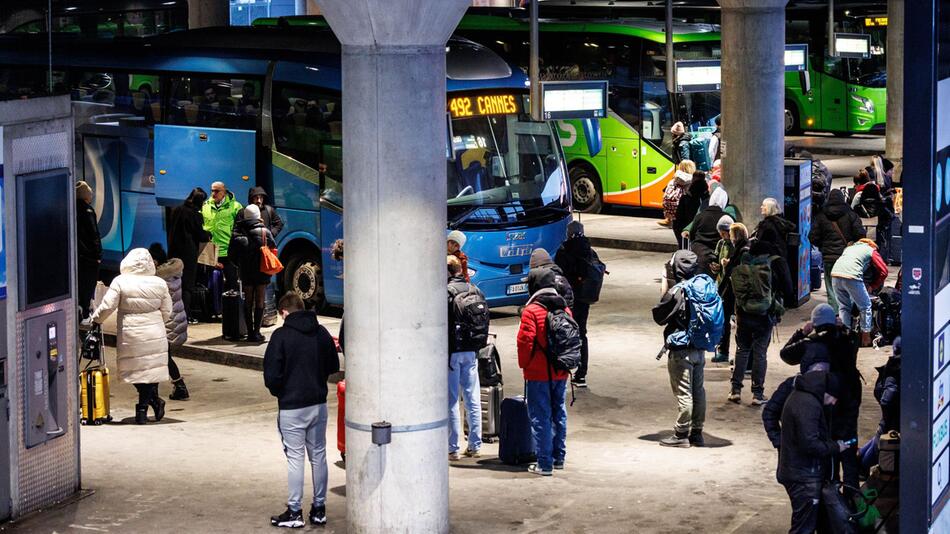 Reisende stehen vor den Fernbussen verschiedener Anbieter