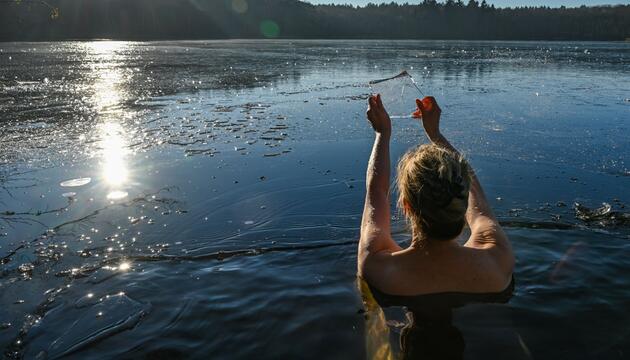 Frau geht in einem Loch im Eis baden