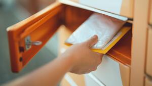 Person leert Briefkasten