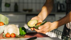 Zwei Hände halten eine aufgeschnittene Avocado.