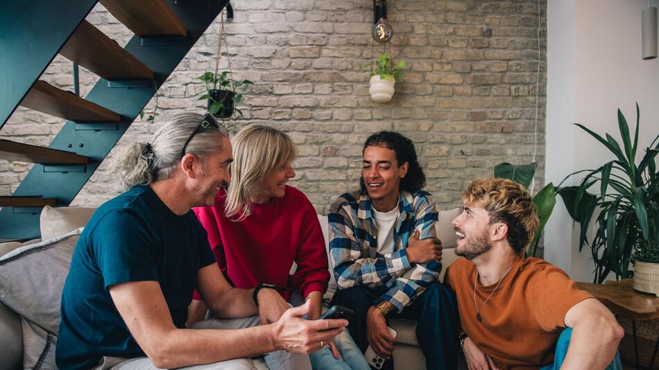 Freunde sitzen gemeinsam im Wohnzimmer