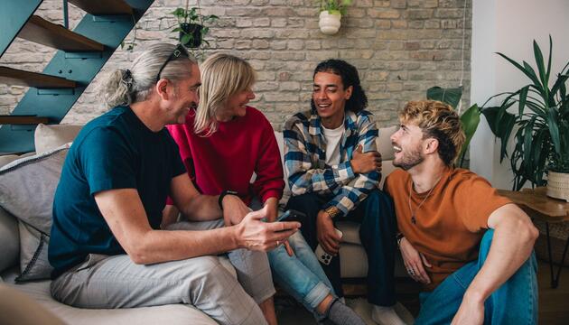 Freunde sitzen gemeinsam im Wohnzimmer