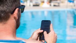 Mann mit Handy am Hotelpool
