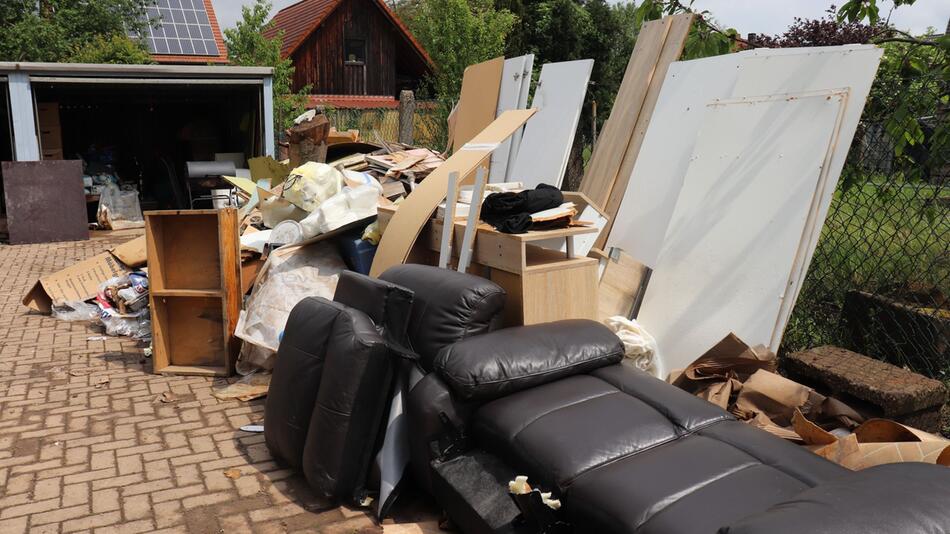 Hausrat stapelt sich nach Hochwasser in einem Hof