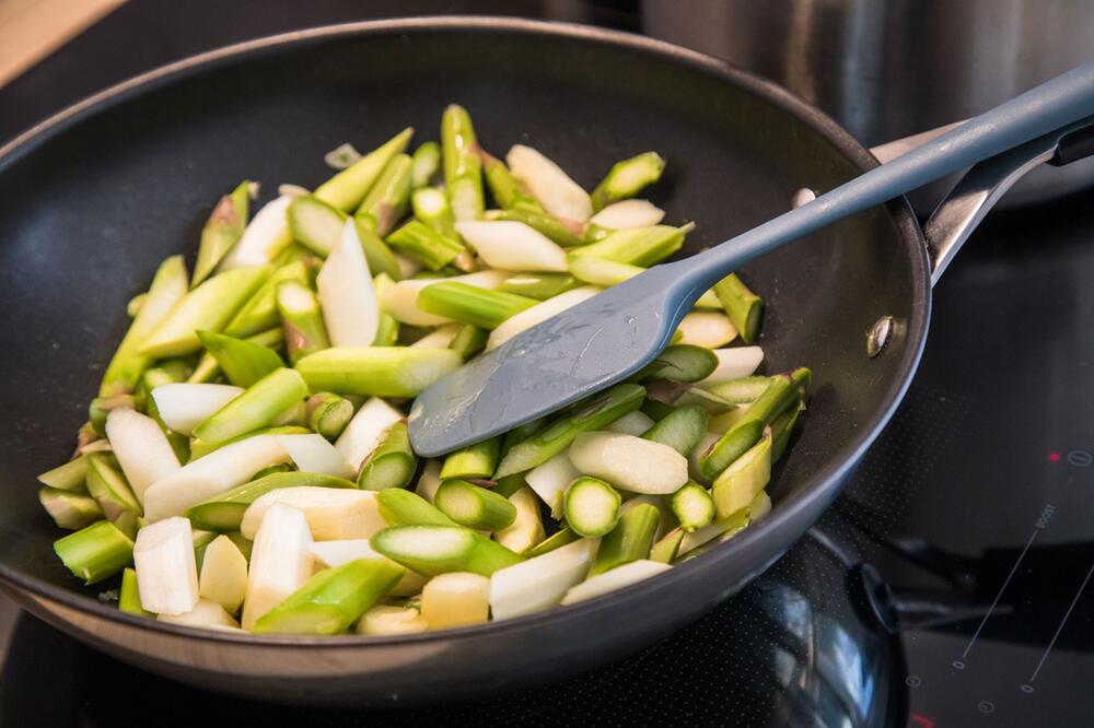 Grüner und weißer Spargel werden in einer Pfanne angebraten