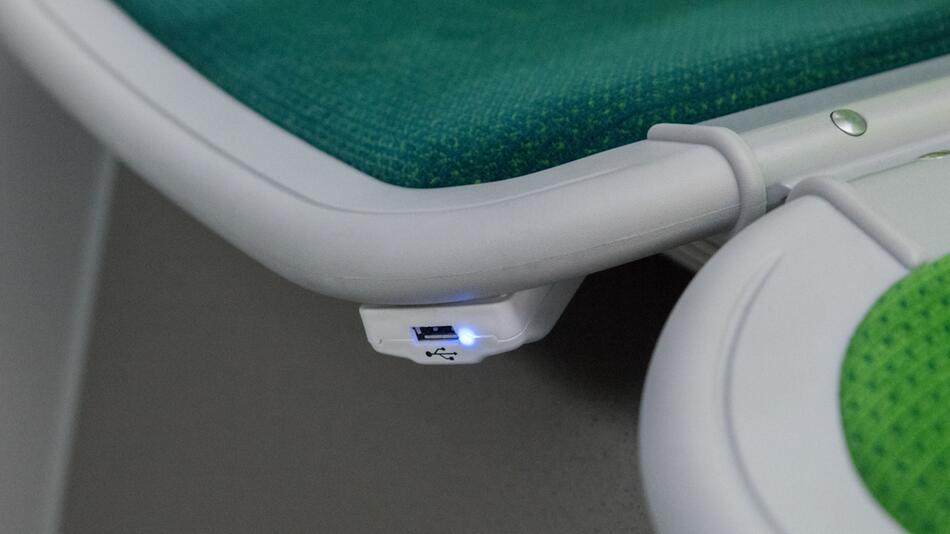 Eine per USB-Anschluss nutzbare, öffentliche Ladestation unter einem Sitz in einer Bahn