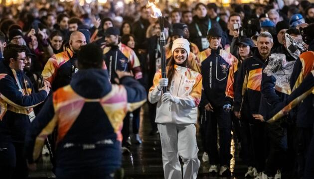 Die Balletttänzerin Nicoletta Manni trägt die olympische Fackel.