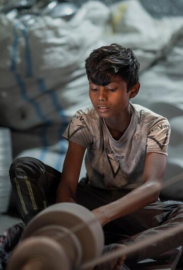 Ein Kind arbeitet in einer Silberpolierfabrik in Bangladesh