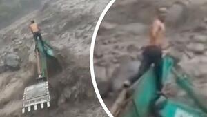 Inmitten der Fluten: Arbeiter rettet sich vor reißendem Wasser auf Bagger