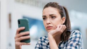 Junge Frau blickt skeptisch auf ihr Smartphone