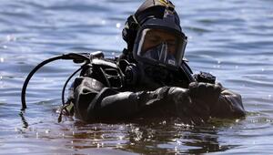 Taucher mit Taucheranzug und Sauerstoffflaschen auf dem Rücken kurz vor Tauchgang. 