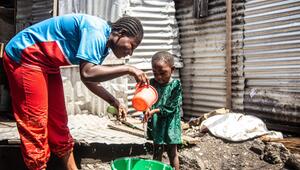 Eine Frau hilft einem Kind beim Händewaschen