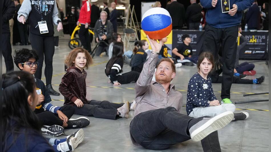 So geht's: Prinz Harry machte den Kindern vor, wie man Sitzvolleyball spielt.