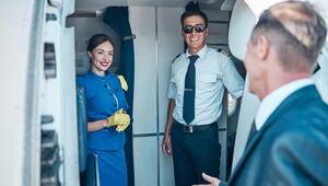 Flugbegleiterin und Pilot begrüßen Fluggast