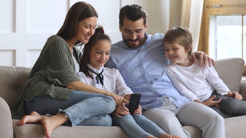 Eine glückliche Familie sitzt auf der Couch