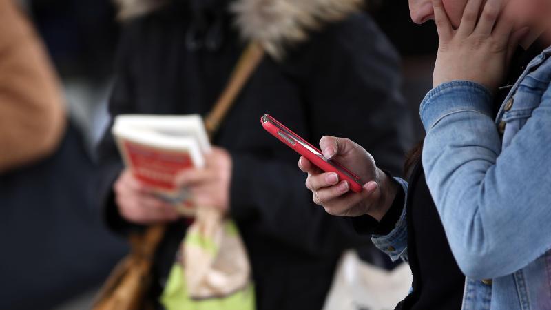 Eine Frau blickt auf ihr Smartphone